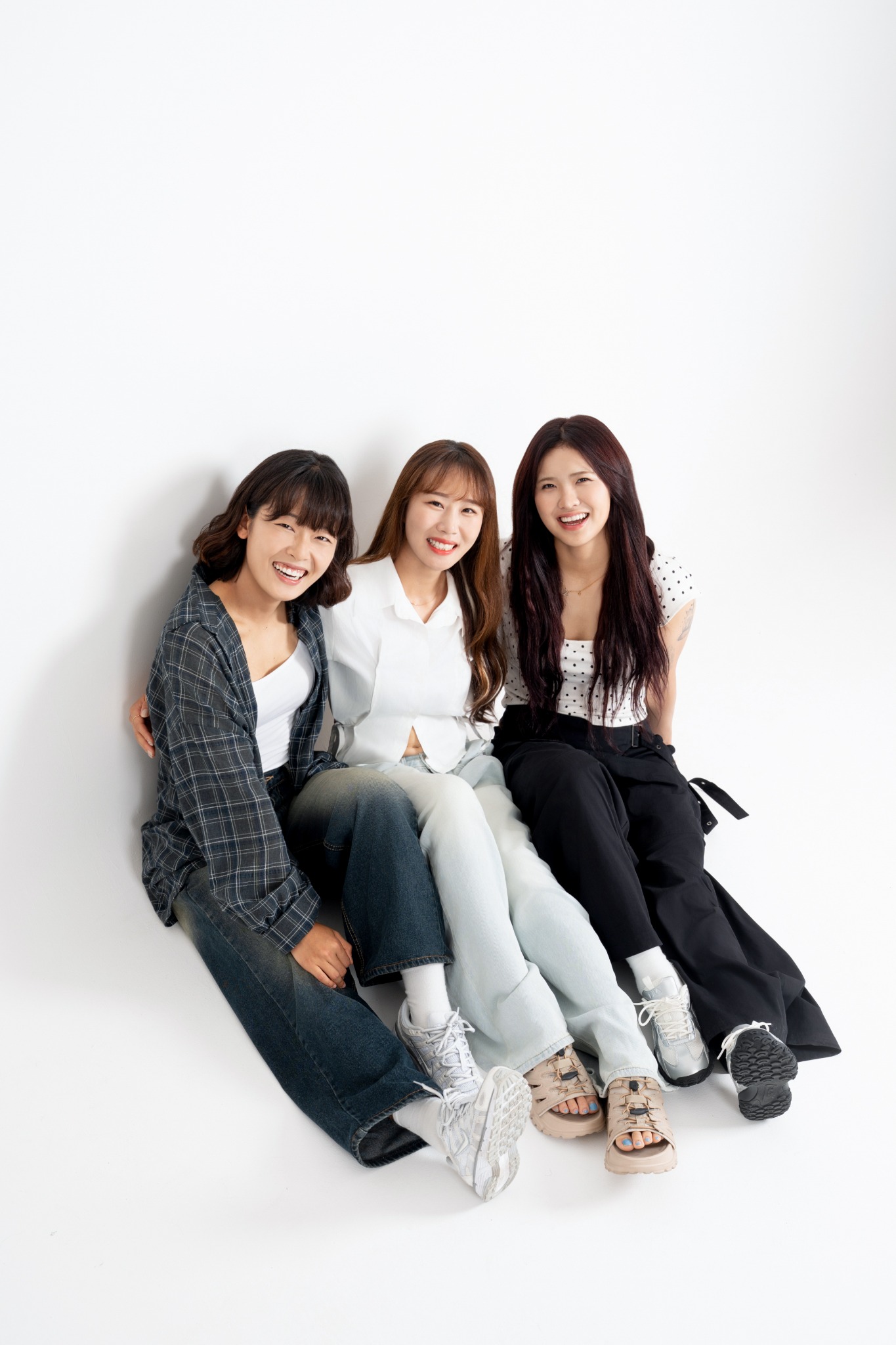 밝은 배경에 나란히 앉아 웃는 세 사람의 우정 프로필